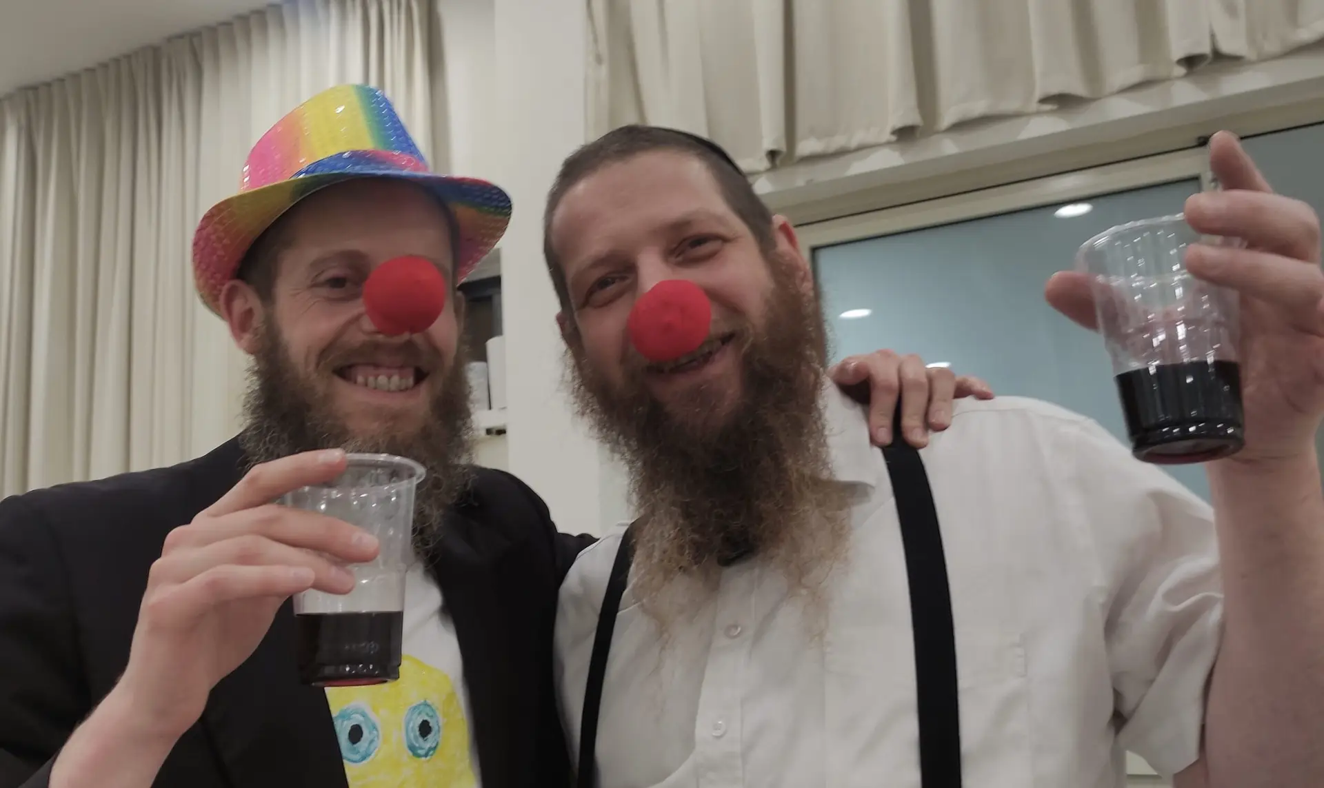 Two Ohr Chabad community members celebrating Purim with costumes and drinks